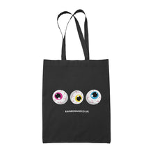 Load image into Gallery viewer, A black tote bag with three cartoonish eyeballs in a row, each with different coloured irises: pink, yellow, and blue. The design is finished with the text &quot;RAINBOWANDCO.UK&quot; beneath the eyeballs.