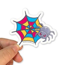 Load image into Gallery viewer, A hand holding a cute spider sticker with a pansexual pride web design. The web is decorated with pink, yellow, and blue segments, symbolising the pansexual flag.