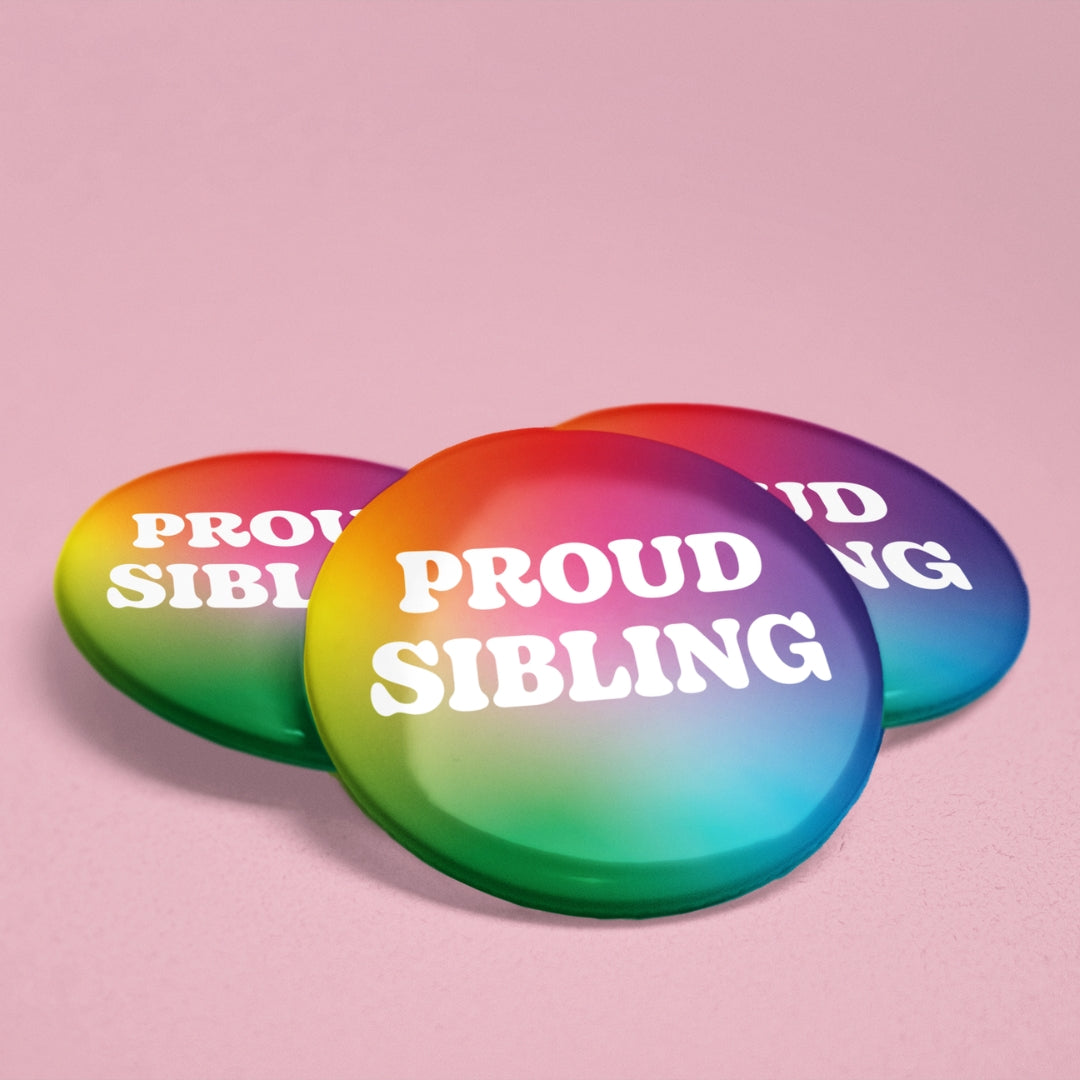 Three Proud Sibling rainbow gradient badges displayed on a pink background, showing glossy finish and 38mm size.