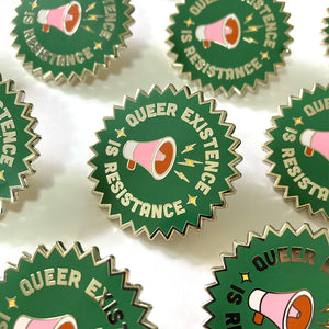 Collection of Queer Existence is Resistance enamel pins lined up in rows