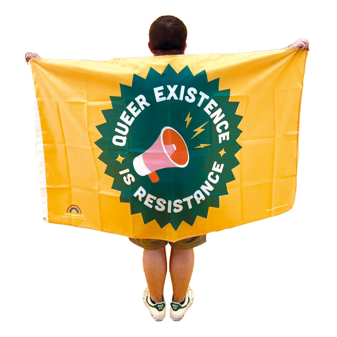 Young man with back to camera wearing a 5ft x 3ft Queer Existence is Resistance Flag around his shoulders - Rainbow & Co