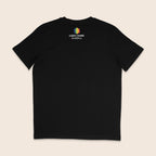 Back of a black T-shirt featuring the LGBT+ Fund logo below the neckline, with a rainbow geometric icon and “powered by Consortium” underneath.