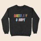 Black sweatshirt with colourful “Queer Joy & Hope” text across the chest in rainbow and trans Pride-inspired colours.