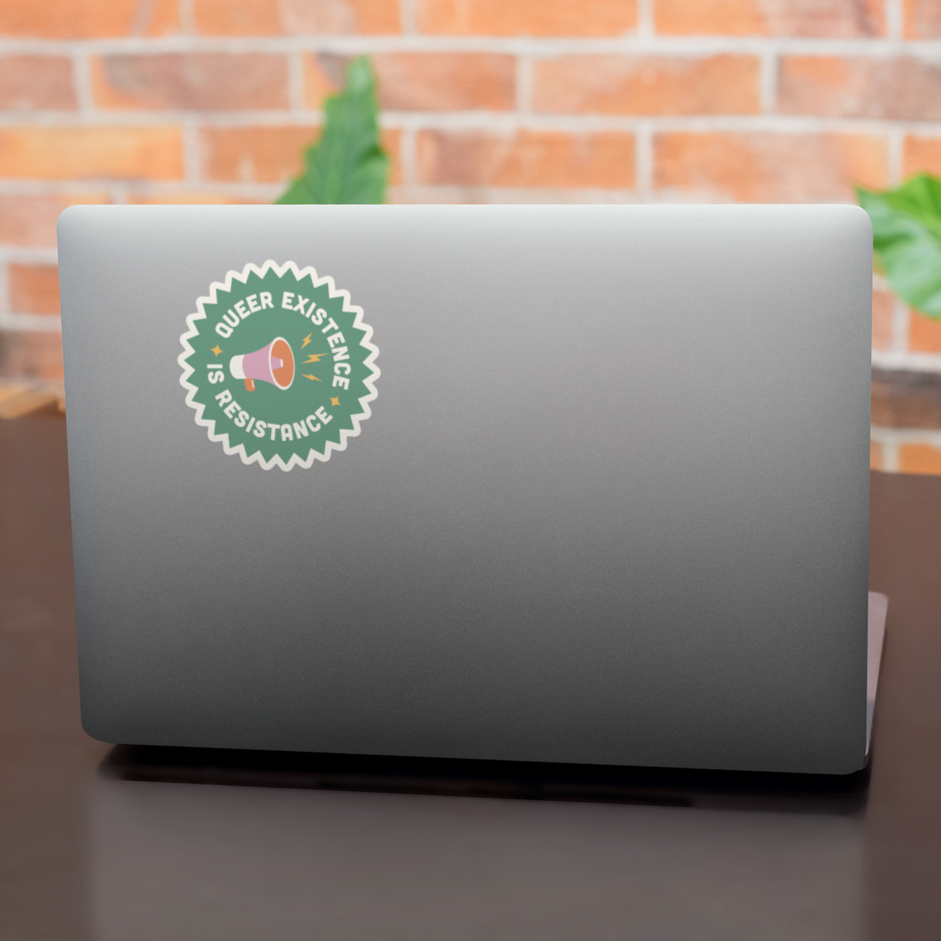 Queer Existence is Resistance sticker on laptop lid