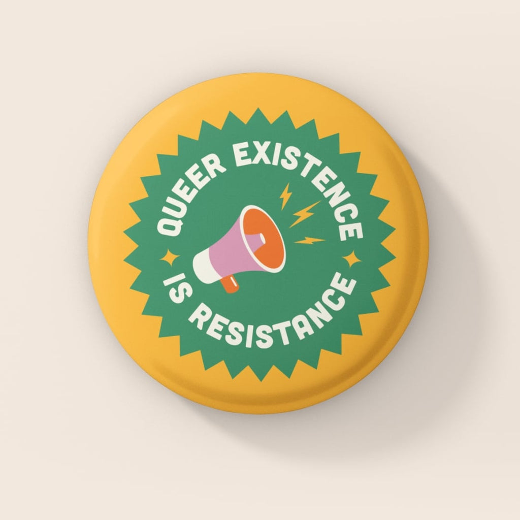 38mm Queer Existence Is Resistance badge with yellow background, green starburst design and megaphone illustration on pink backdrop.