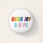 White round 38mm badge featuring the words "Queer Joy & Hope" in bold, multicoloured lettering inspired by the rainbow and transgender Pride flags.