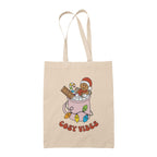 Natural tote bag featuring retro text reading 'cosy vibes'. The image shows a mug of hot chocolate with marshmallows and a gingerbread man wearing a Santa hat. A candy cane in the mug and lights around the mug are the colours of the rainbow pride flag.