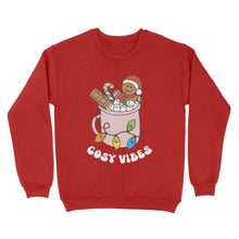 Load image into Gallery viewer, Fire Red sweatshirt featuring retro text reading &#39;cosy vibes&#39;. The image shows a mug of hot chocolate with marshmallows and a gingerbread man wearing a Santa hat. A candy cane in the mug and lights around the mug are the colours of the rainbow pride flag.