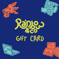 A colourful digital gift card design featuring the Rainbow & Co logo in lime green against a dark blue background. The words “GIFT CARD” are handwritten beneath the logo. Surrounding the text are bright illustrations: a red megaphone, a teal laptop with stickers reading “BIG GAY DO CRIME,” a teal hand holding protest signs with queer slogans like “Protect Trans Kids,” and red parcels with handwritten labels such as “From Adam, with love.”