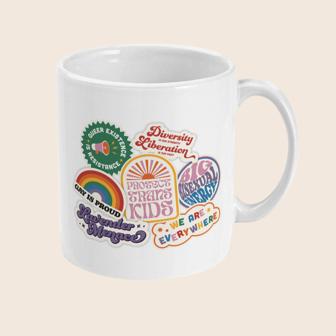 White ceramic mug covered in colourful sticker-style pride graphics, including slogans like “Queer Existence is Resistance,” “Protect Trans Kids,” “Gay is Proud,” “Lavender Menace,” “Big Bisexual Energy,” “Diversity is Our Strength, Liberation is Our Right,” and “We Are Everywhere.”