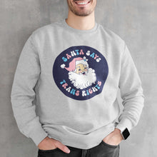 Load image into Gallery viewer, Young man wearing a heather grey sweatshirt with a Santa Says Trans Rights motif in the colours of the Transgender flag