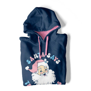 A folded Oxford Blue hooded sweatshirt with contrasting pink inner hood and drawcords on a white background. The hoodie features the design Santa Says Trans Rights and an image of Santa Claus in the colours of the transgender flag.