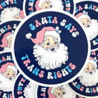 75mm circular vinyl sticker with navy blue background and text reading Santa Says Trans Rights with an illustration of Santa Claus
