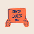 Shop Queer vinyl sticker featuring illustrated hands holding an orange protest sign with the words "Shop Queer".