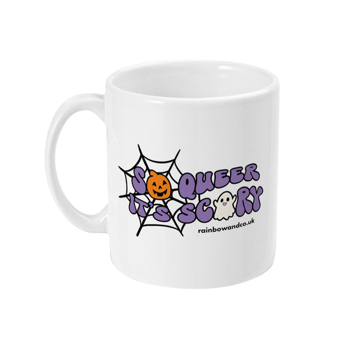 A white ceramic coffee mug with the handle on the left. The mug shows the slogan So Queer It's Scary alongside halloween icons of a pumpkin, ghost, and spiders web