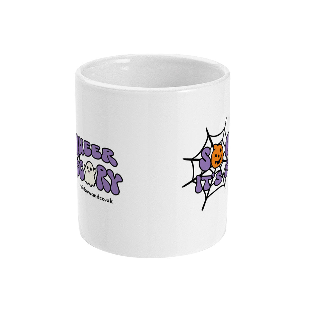A white ceramic coffee mug with handle facing away from view. The mug shows the slogan So Queer It's Scary alongside halloween icons of a pumpkin, ghost, and spiders web