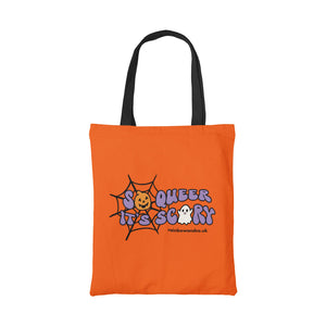 Orange cotton tote bag with black handle featuring the slogan So Queer It's Scary alongside halloween icons of a pumpkin, ghost, and spiders web