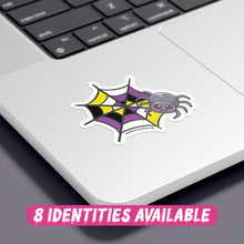 Load image into Gallery viewer, A colourful sticker featuring a cartoon spider with red eyes, resting on a spider web with a pattern that combines black, yellow, white, and purple colours, representing the non binary flag. The sticker is placed on the corner of a silver laptop, showcasing its vibrant design against the sleek surface. At the bottom, there is text in a playful pink font that reads &quot;8 Identities Available.&quot;