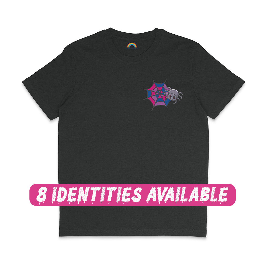 A dark heather grey t-shirt featuring a small spider and web graphic on the left chest area. The web is designed in pink, purple, and blue, representing bisexual pride colours. A smiling spider is positioned next to the web. Below the t-shirt, there is a pink banner with white text that reads "8 IDENTITIES AVAILABLE," indicating that this design comes in various LGBTQ+ identities.