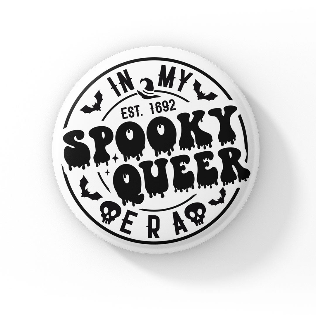 A round badge with a white background featuring the text "In My Spooky Queer Era" in black, with a Halloween-themed design. The words "Spooky Queer" are styled with dripping, spooky letters, surrounded by small illustrations of bats and skulls. The text "EST. 1692" is included, referencing the year of the Salem witch trials.