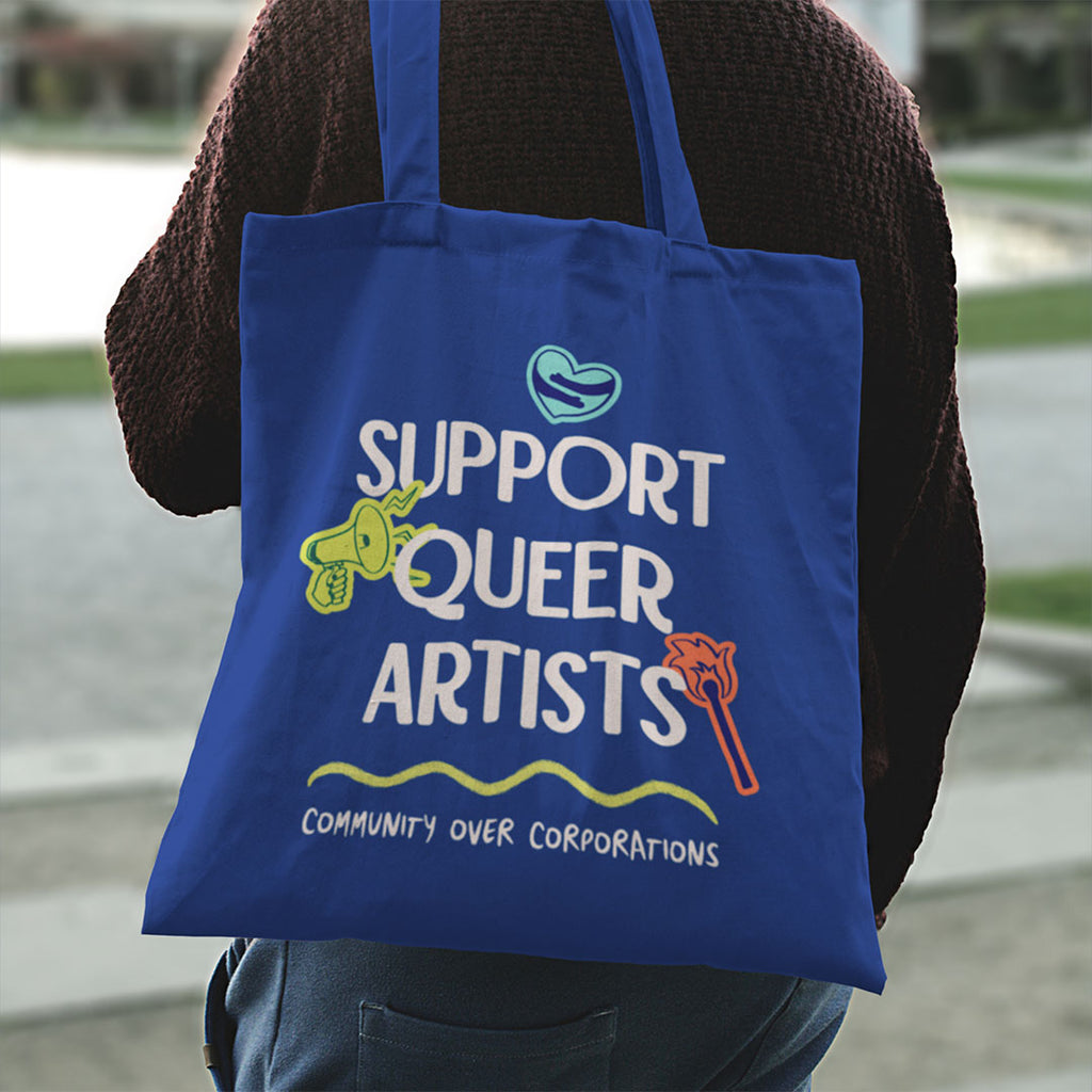Rear view of a person wearing a royal blue Support Queer Artists tote bag with colourful graphic design celebrating queer artists and independent creators.