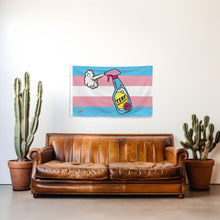 Load image into Gallery viewer, Brown leather sofa in a room with a Trans Pride flag featuring a spray bottle of TERF Repellent on the wall, potted cacti on either side.