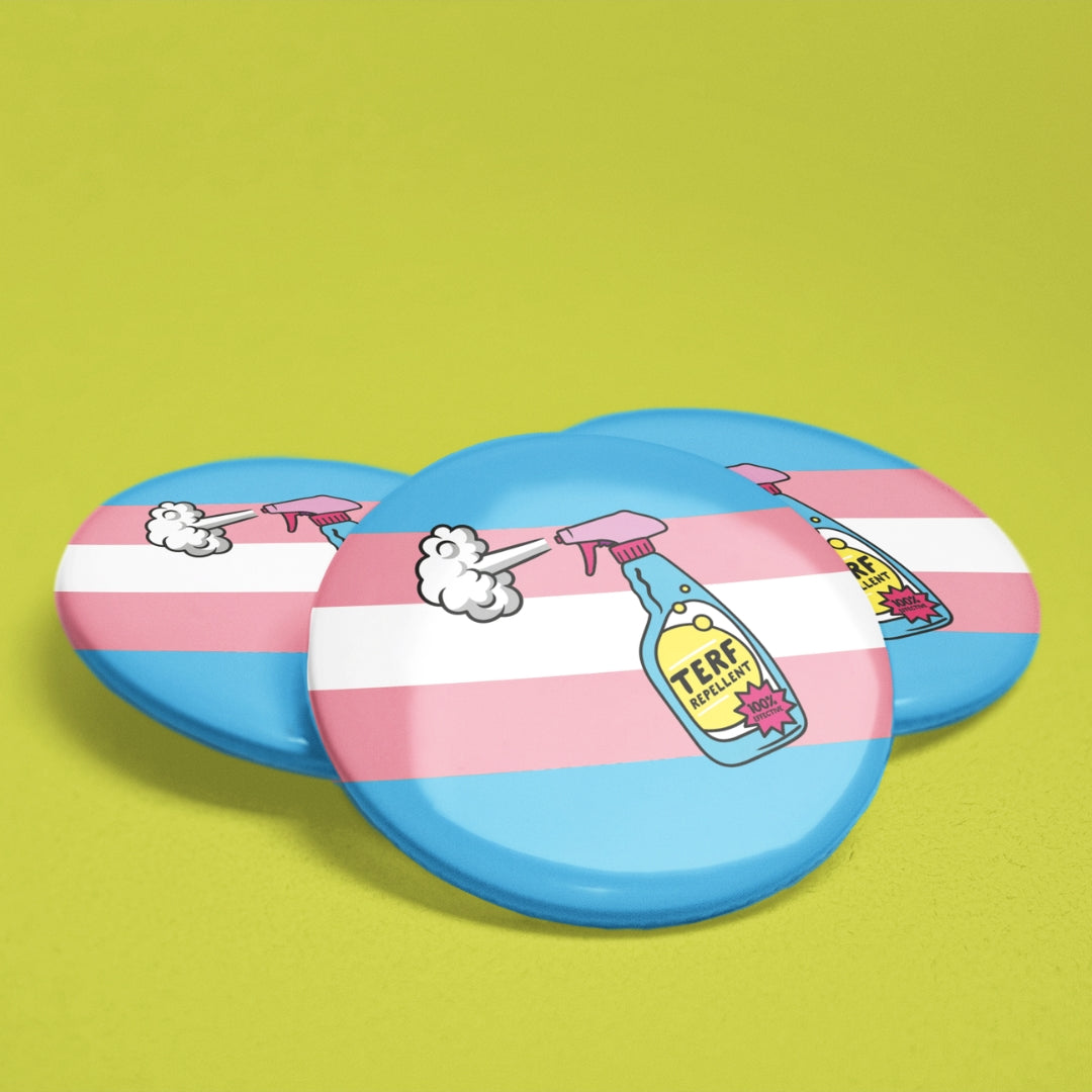 Three 38mm round badges featuring the trans pride flag colours with an illustrated spray bottle labelled “TERF Repellent – 100% Effective” on a blue and pink striped background.