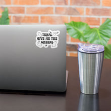 Load image into Gallery viewer, A white sticker with the text &quot;TERFs Give Me The Creeps&quot; in black, featuring small ghost and bat illustrations, is affixed to the top corner of a grey laptop. The laptop is on a desk beside a silver insulated tumbler with a clear lid, in front of a brick wall background with green leafy plants.