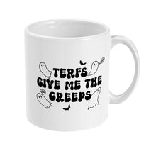 Load image into Gallery viewer, The right side of a white ceramic mug displaying a cartoon ghost and bat design with the bold text &quot;TERFs Give Me The Creeps&quot; in a spooky, Halloween-themed font, creating a playful and eerie look.