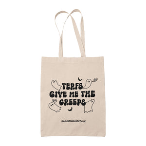 A natural cotton tote bag featuring the text "TERFs Give Me the Creeps" in a bold, spooky font with ghost illustrations around it. A bat graphic is included in the design, and the website "RAINBOWANDCO.UK" is printed at the bottom.