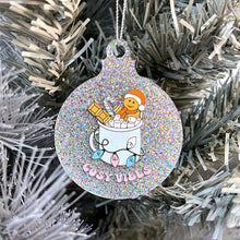 Load image into Gallery viewer, Close up of a white Christmas tree displaying a silver glitter bauble featuring retro text reading &#39;cosy vibes&#39;. The image shows a mug of hot chocolate with marshmallows and a gingerbread man wearing a Santa hat. A candy cane in the mug and lights around the mug are the colours of the transgender pride flag.