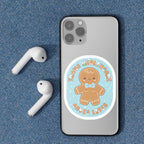 A close-up of a mobile phone with the "Trans Healthcare Saves Lives" sticker, featuring a gingerbread person wearing a bow tie and proudly displaying trans representation.
