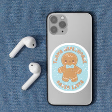 Load image into Gallery viewer, A close-up of a mobile phone with the &quot;Trans Healthcare Saves Lives&quot; sticker, featuring a gingerbread person wearing a bow tie and proudly displaying trans representation.