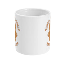 Load image into Gallery viewer, Side view of a white mug with the design partially visible, featuring a gingerbread figure with a blue bow tie and the phrase &quot;Trans Healthcare Saves Lives&quot; in a circular design.