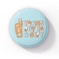 Single light blue badge on a white background with gingerbread present illustrations and the text "Trans Joy is a Gift.