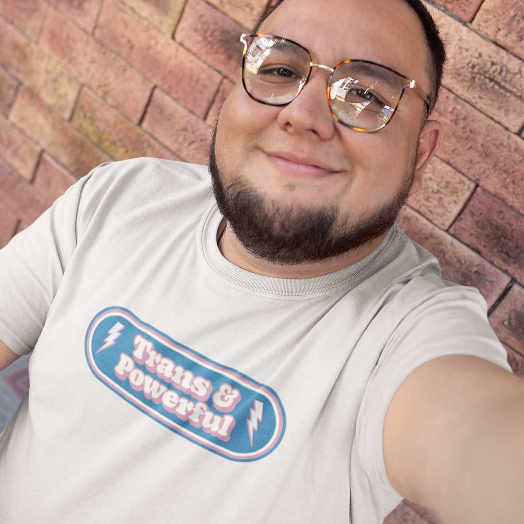 Man with facial hair and glasses wearing a Trans & Powerful shirt from Rainbow & Co