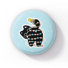 Load image into Gallery viewer, A black cat wrapped in string lights in the colours of the transgender flag (blue, pink, and white), sitting on a light blue background with snowflakes.