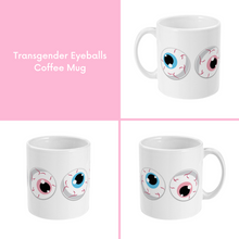 Load image into Gallery viewer, A composite image of a white coffee mug with a cartoon eyeball design in transgender pride flag colours.