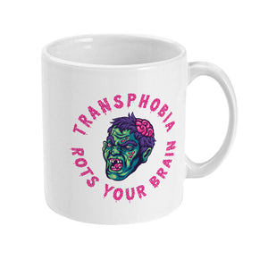 The right side of a white ceramic mug, showing a partial view of the zombie-like face design. The pink text "TRANSPHOBIA ROTS YOUR BRAIN" curves around the image, emphasizing the anti-transphobia message.