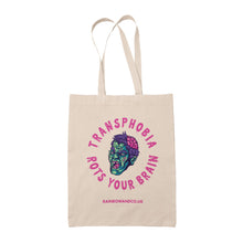 Load image into Gallery viewer, A natural tote bag featuring a similar design to the &quot;Homophobia Rots Your Brain&quot; tote, but with the text &quot;Transphobia Rots Your Brain&quot; instead. The design includes a zombie face illustration and the website &quot;RAINBOWANDCO.UK&quot; at the bottom.