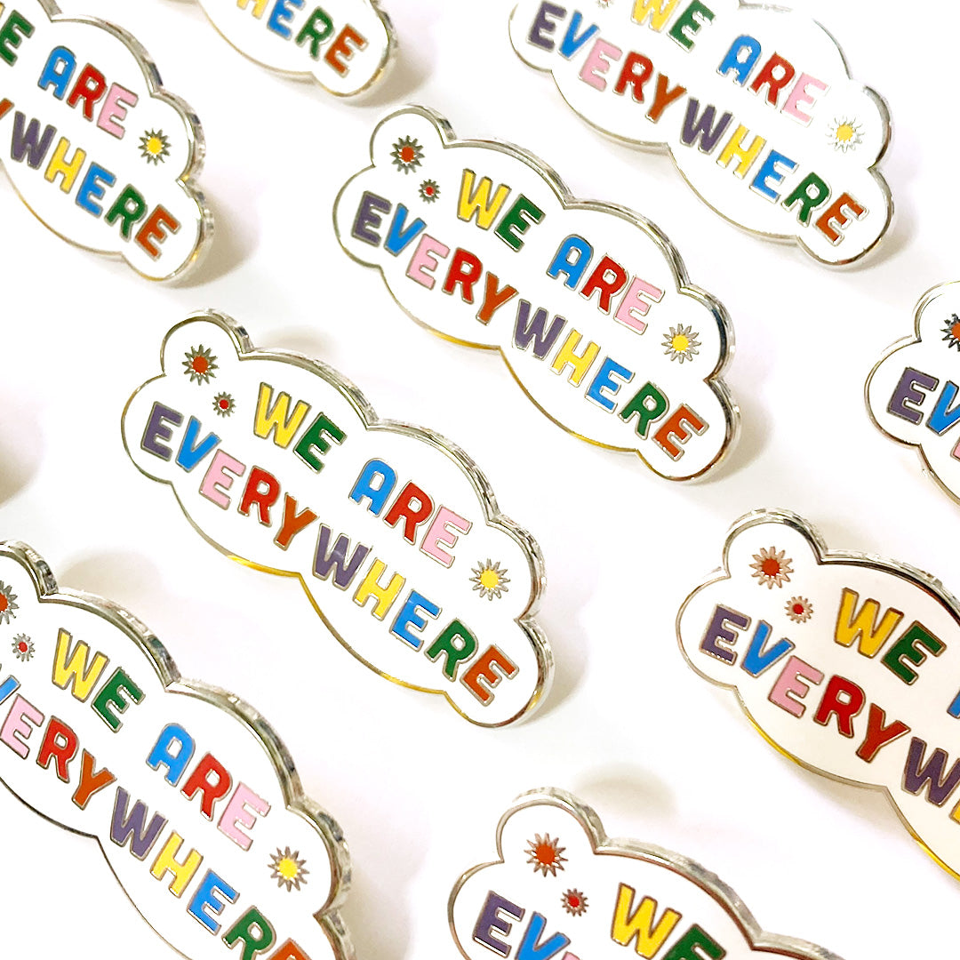 A collection of We Are Everywhere enamel pins lined up in rows