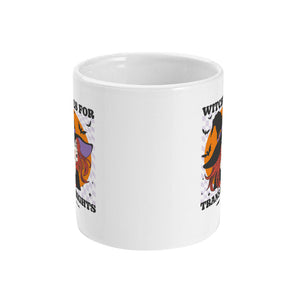 A white ceramic coffee mug with handle facing away from view. The mug shows the slogan Witches for Trans Rights with an illustrated graphic of a witch with bats flying around her hat