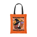 Orange cotton tote bag featuring the slogan Witches for Trans Rights with an illustrated graphic of a witch with bats flying around her hat