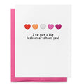 White greeting card with five hearts in the colours of the lesbian pride flag above the words "I've got a big lesbian crush on you!" with a pink envelope behind.
