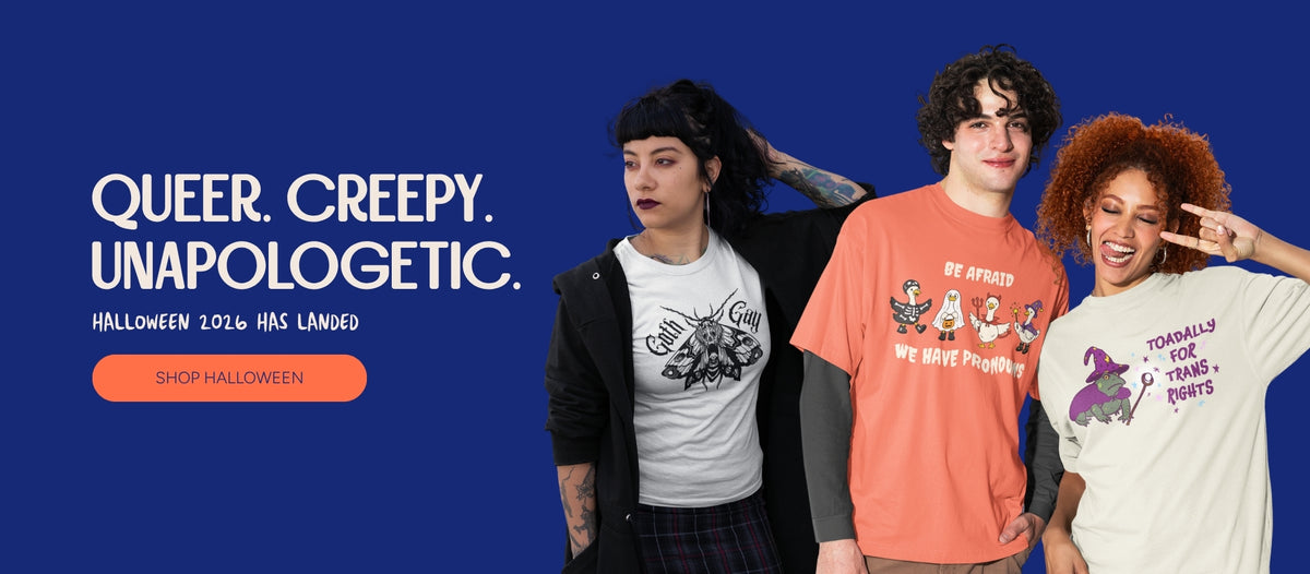 Halloween collection banner with three models wearing Rainbow & Co's Goth Gay moth, Be Afraid We Have Pronouns geese, and Toadally for Trans Rights T-shirts on a navy background. Text reads “Queer. Creepy. Unapologetic. Halloween 2026 has landed” with a Shop Halloween button.