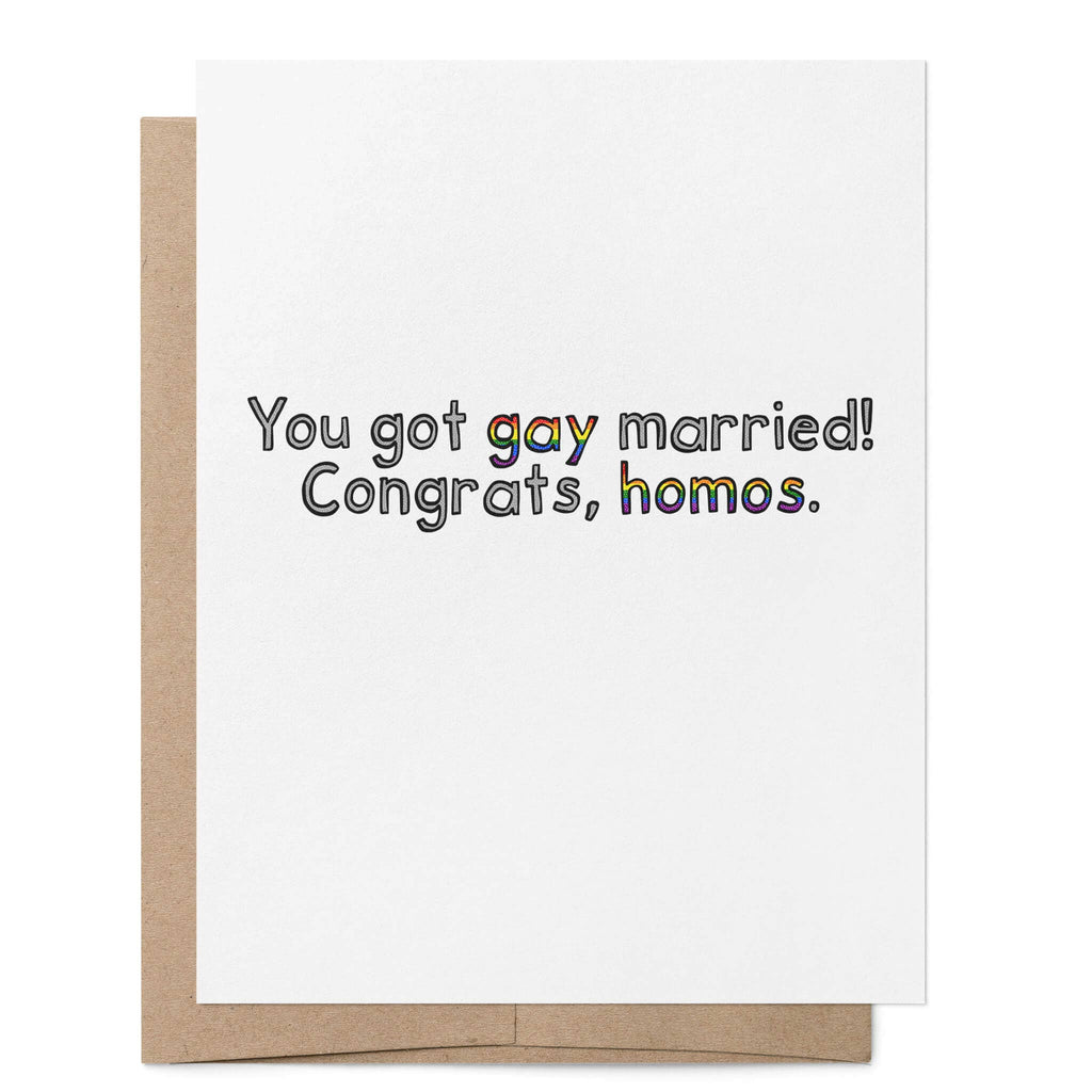 White greeting card featuring the words "You got gay married! Congrats, homos." with the words "gay" and "homos" written in rainbow lettering, with a brown kraft envelope behind.