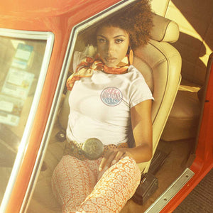 Retro style photo of a black woman with an afro sat in a classic retro car wearing a Big Bisexual Energy shirt