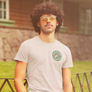 Retro style photo of a man with curly dark hair and vintage sunglasses wearing a Queer Existence is Resistance t shirt from Rainbow & Co